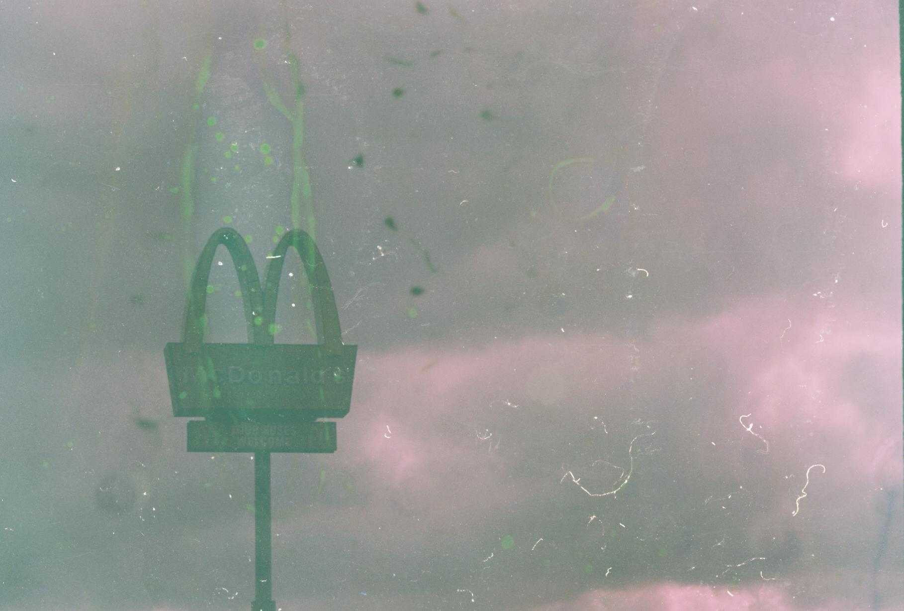 a pylon mcdonald's sign with a cloudy sky behind it