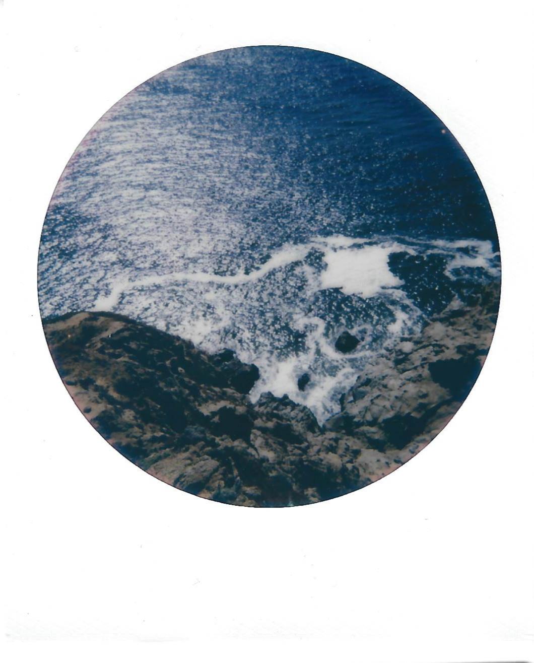 the ocean seen from the top of a rocky cliffside