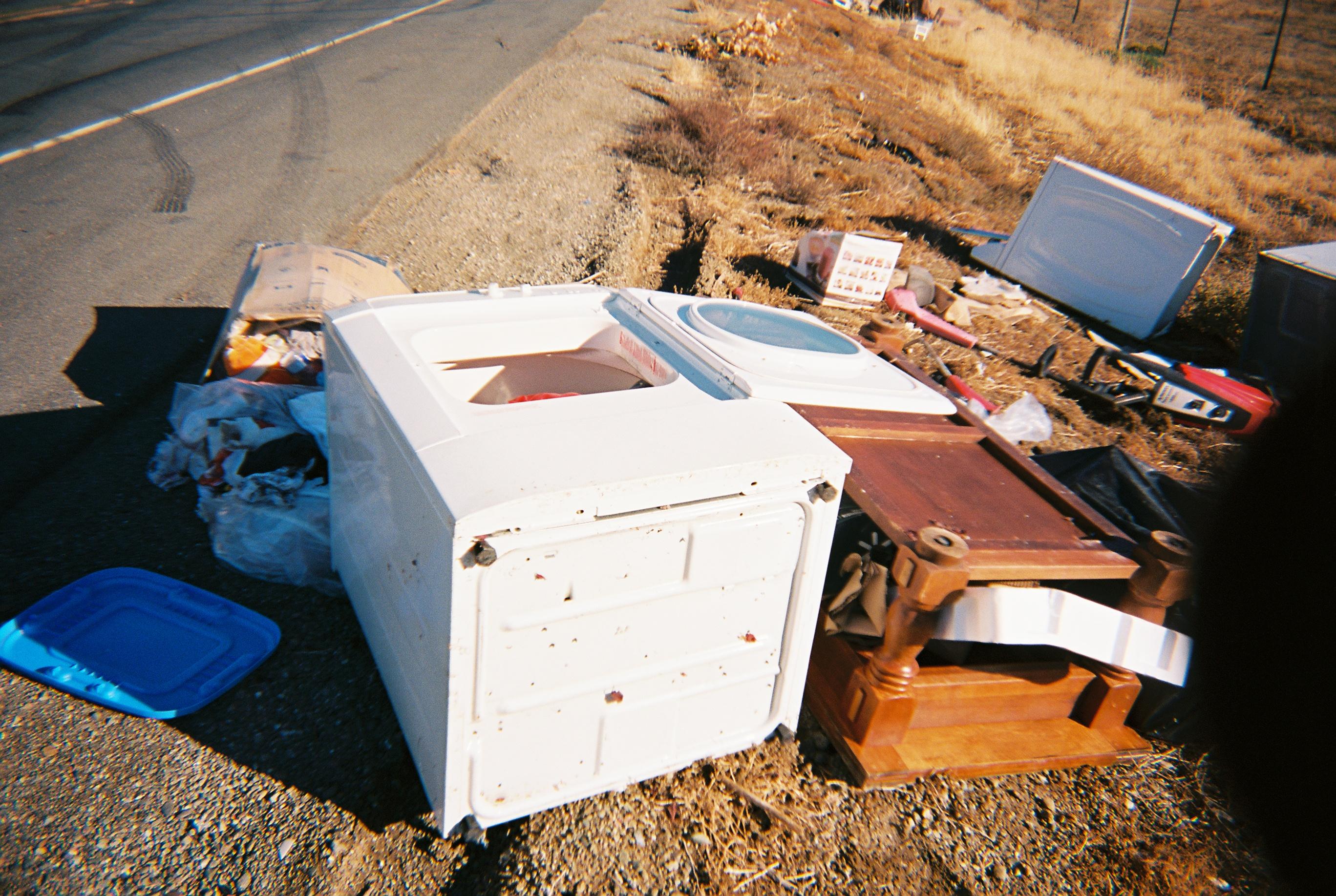 a tipped over dryer on the side of the road