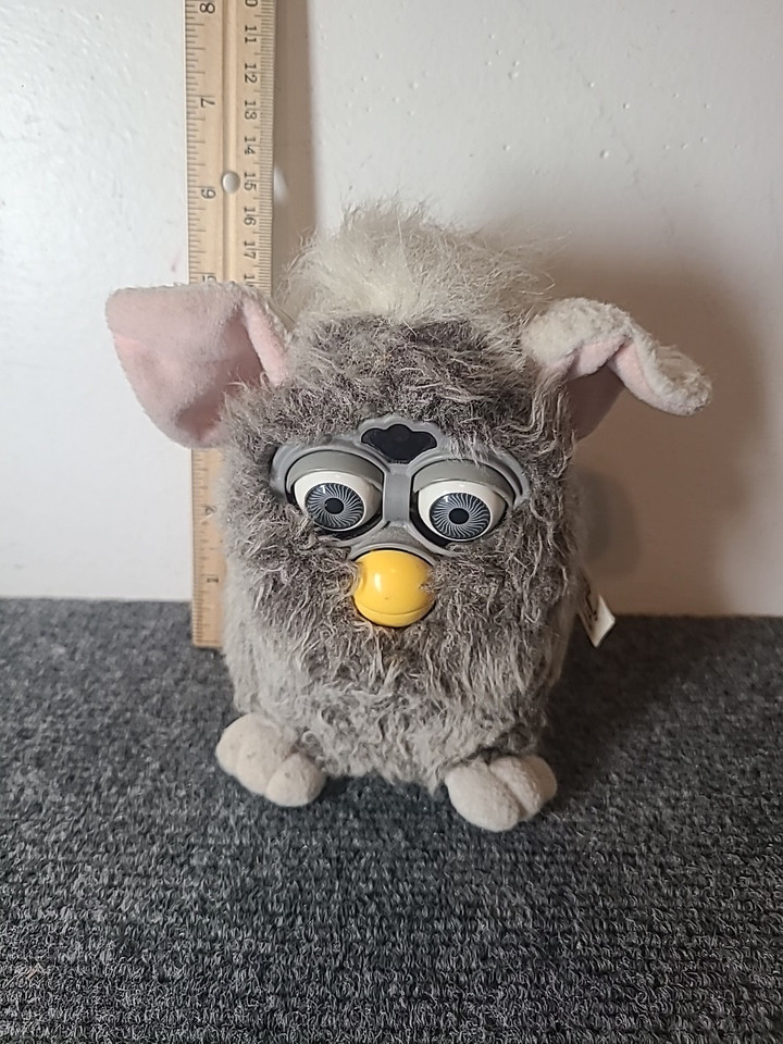 a furby looking down scaredly